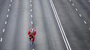 Pelari mengenakan kostum Sinterklas ambil bagian dalam Santa Claus Run di Madrid, Spanyol, Minggu (9/12). Ribuan orang berjalan dan berlari dalam perlombaan Santa tahunan melintasi jalan-jalan ibu kota Spanyol. (Gabriel BOUYS / AFP)