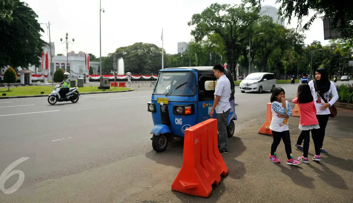 Penumpang turun dari angkutan umum jenis bajaj di kawasan Monas, Jakarta, Rabu (20/7). Sudinhubtrans Jakarta Pusat segera menerapkan larangan bajaj melintas di Jalan Medan Merdeka Barat dan Medan Merdeka Utara. (Liputan6.com/Gempur M Surya)
