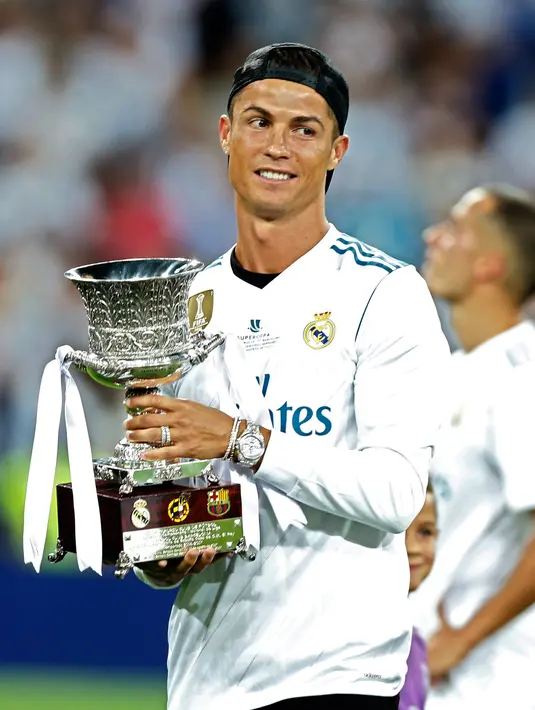 Penyerang Real Madrid, Cristiano Ronaldo memegang trofi Piala Super Spanyol 2017 usai pertandingan melawan Barcelona di stadion Santiago Bernabeu, Spanyol (16/8). Real Madrid menang 2-0 atas Barcelona dengan skor agregat 5-1. (AP Photo/Francisco Seco)