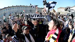 Ribuan suporter Juventus berteriak merayakan kemenangan usai merebut gelar Serie A Italia di pusat kota Turin, Italia (25/4). Juventus berhak meraih gelar Scudetto mereka yang ke-34. (REUTERS/Giorgio Perottino)
