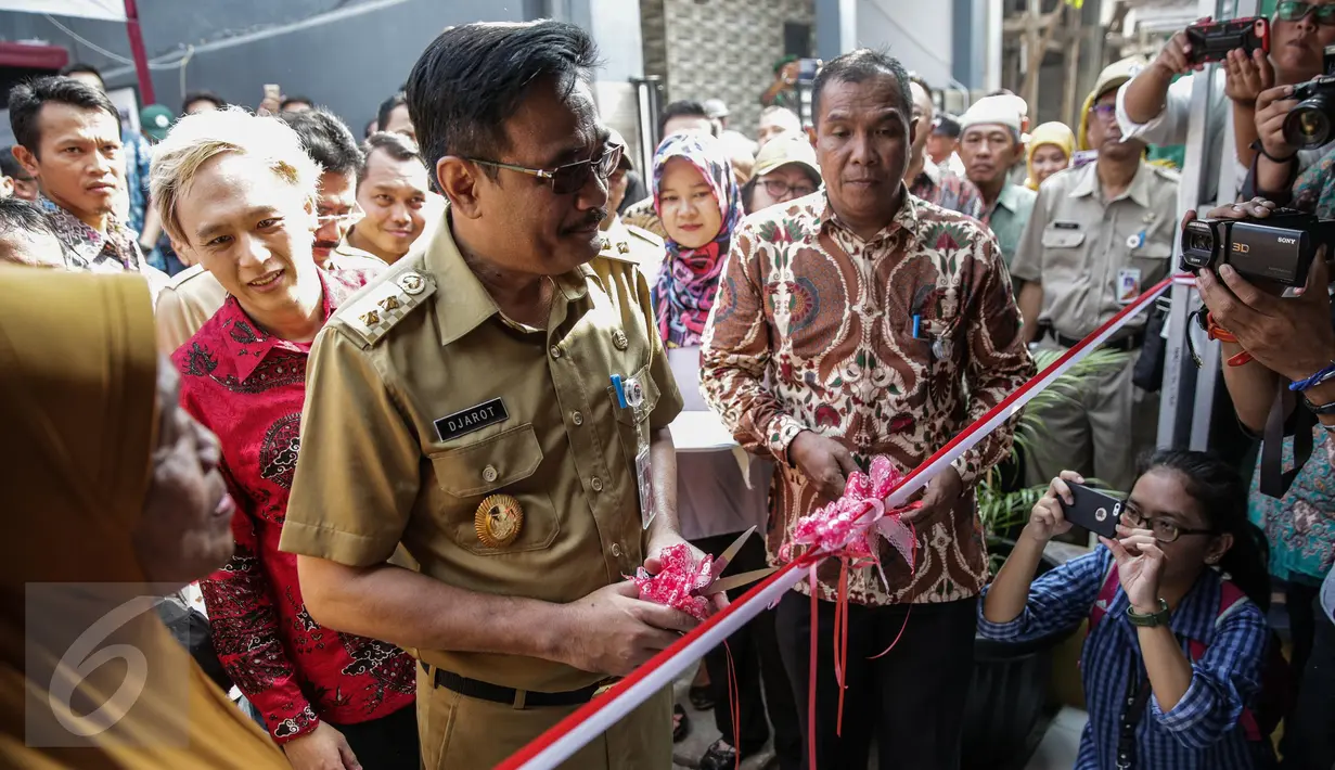 Wagub DKI Jakarta, Djarot Saiful bersiap memotong pita saat meresmikan program bedah rumah di Cilincing, Jakarta, Senin (17/4). Dalam pendataan ada 83 rumah warga yang tak layak huni sudah masuk dalam program bedah rumah. (Liputan6.com/Faizal Fanani)