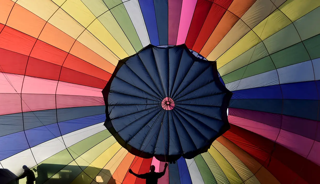 Peserta menyiapkan balon udaranya untuk diterbangkan saat mengikuti Bristol International Balloon Fiesta ke 37  di Inggris, Jumat (7/8/2015). Festival balon terbesar di eropa ini berlangsung selama empat hari.  (REUTERS/Toby Melville)