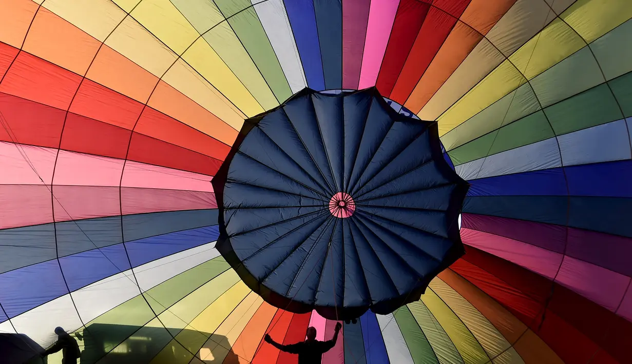 Peserta menyiapkan balon udaranya untuk diterbangkan saat mengikuti Bristol International Balloon Fiesta ke 37  di Inggris, Jumat (7/8/2015). Festival balon terbesar di eropa ini berlangsung selama empat hari.  (REUTERS/Toby Melville)