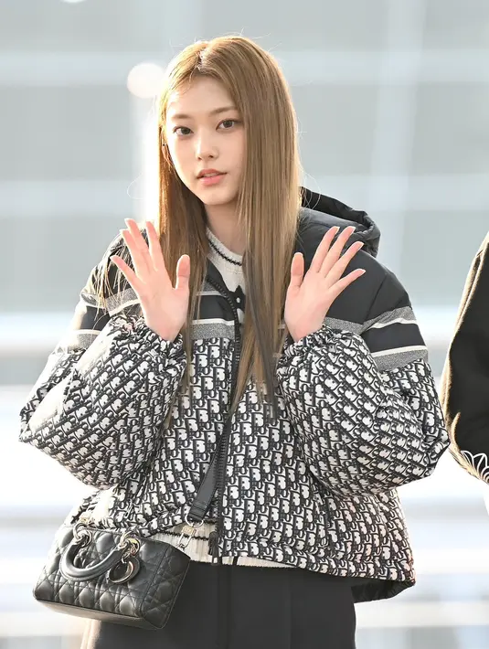 Berangkat menuju Thailand untuk Golden Disk Award, Haerin NewJeans tampil monokrom dalam balutan outfit serba Dior. Ia memadukan Reversible Cropped Down Jacket, Dior Short Sleeved Sweater, Skort with ‘CD’ Button, Dior Emperinte Ankle Boot dan tas Small Lady D-Joy Bag. [Dior].