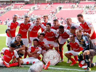 Pemain Arsenal berfoto bersama dengan trofi merayakan kemenangan usai mengalahkan Chelsea pada FA Community Shield di Wembley Stadium, Minggu (2/8/2015). Arsenal menang atas Chelsea dengan skor 1-0. (Reuters/Andrew Couldridge)