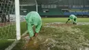 Para petugas berusaha menguras air yang menggenangi lapangan di Stadion Patriot, Bekasi, Senin (13/11/2017). Drainase yang buruk menyebabkan lapangan terendam air. (Bola.com/M Iqbal Ichsan)