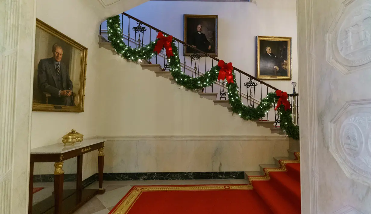 Dekorasi Natal menghiasi tangga utama atau Grand Staircase di Gedung Putih, Washington DC, Senin (26/11). Gedung Putih telah resmi didekorasi untuk menyambut Natal 2018 dengan mengangkat tema 'American Treasures'. (AP/Carolyn Kaster)
