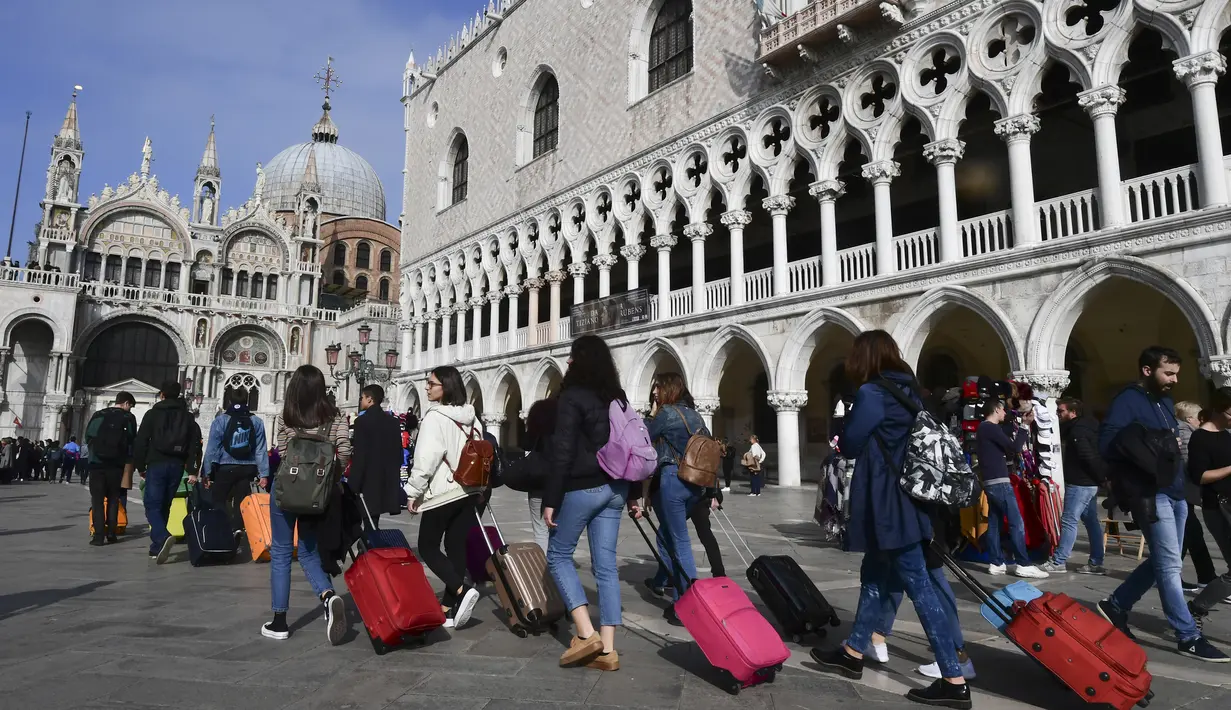 Turis berjalan di sepanjang Doge's Palace menuju Basilika Santo Markus di Venesia (4/11/2019). Kota ini memiliki luas wilayah 412 km² dan populasi 271.663 jiwa (2003). (AFP Photo/Miguel Medina)