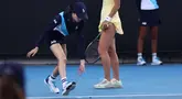 Seorang gadis bola mencoba menangkap serangga yang masuk ke lapangan saat pertandingan Australia Terbuka 2024 antara petenis Inggris Emma Raducanu dan petenis Amerika di Melbourne Park, Melbourne, Australia, Selasa (16/01/2024).  (AFP/David Gray)