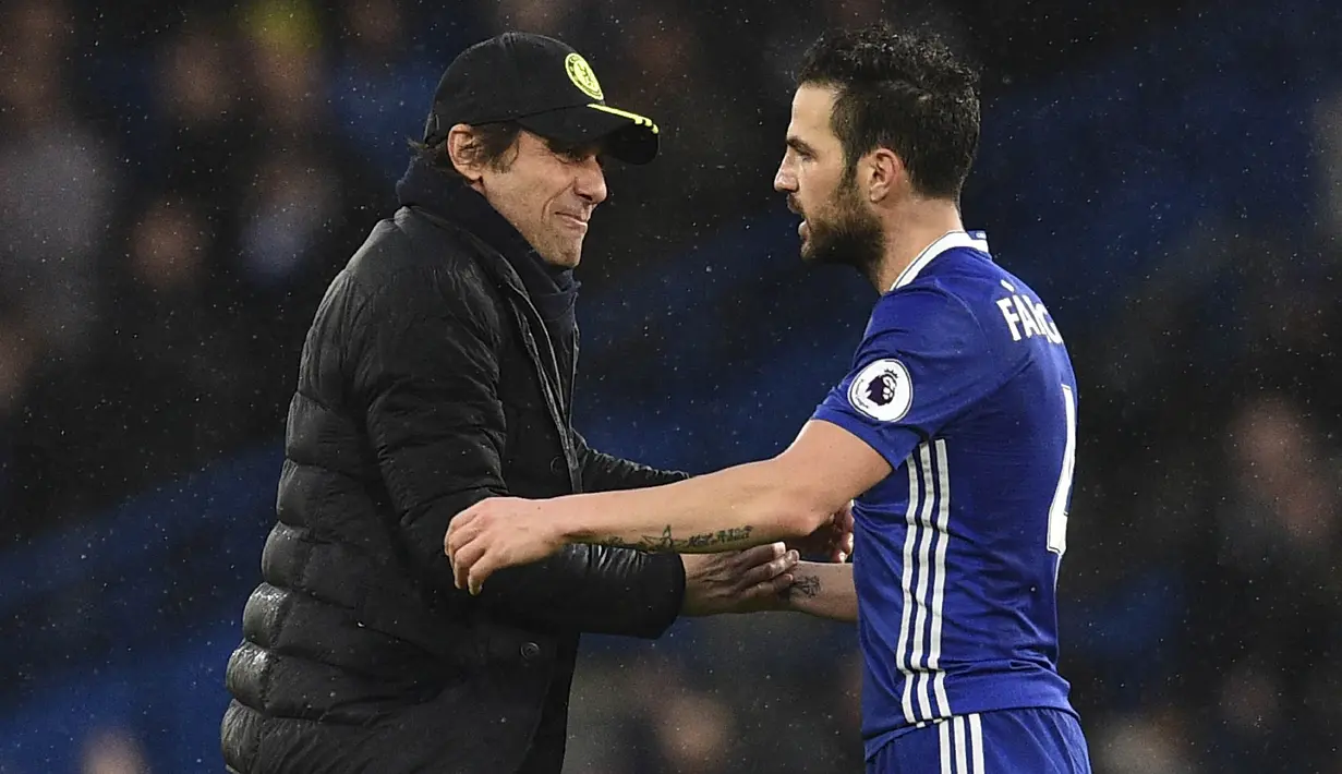 Pelatih Chelsea, Antonio Conte, menyapa Cesc Fabregas usai laga melawan Swansea. Kemenangan ini membuat The Blues kian kokoh memimpin Liga Inggris dengan selisih poin 11 dari Manchester City di peringkat kedua. (AFP/Glyn Kirk)