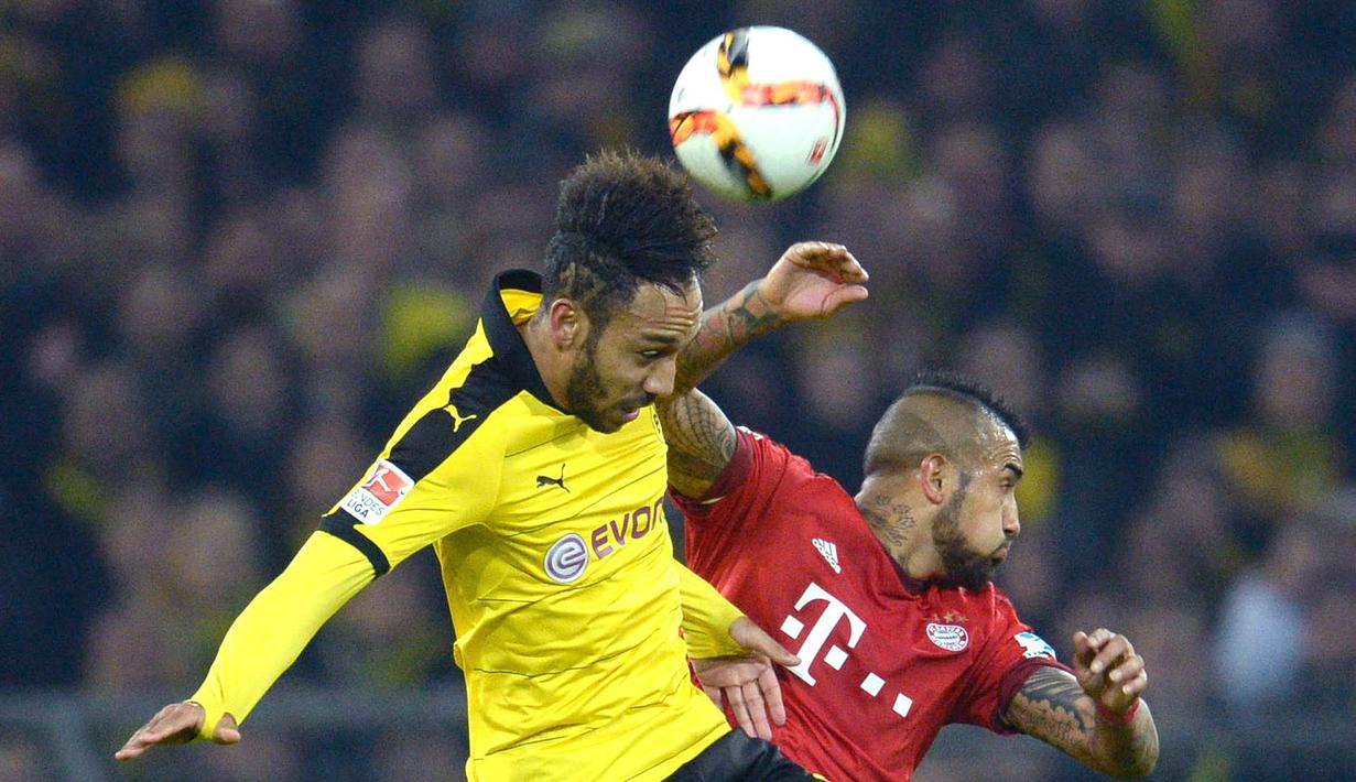 Pemain Munchen, Arturo Vidal (kanan) berebut bola dengan pemain Dortmund, Pierre-Emerick Aubameyang  pada lanjutan Bundesliga 2015-2016 di Stadion Signal Iduna Park ,Dortmund, Minggu (5/3/2016) dini hari WIB. (EPA/Bernd Thissen)