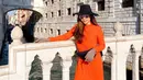 Gaya bohemian dengan tunic oranye, boater hat, dan sepatu boots kala berlibur di Italia. [Foto: IG/jenny.mci8].