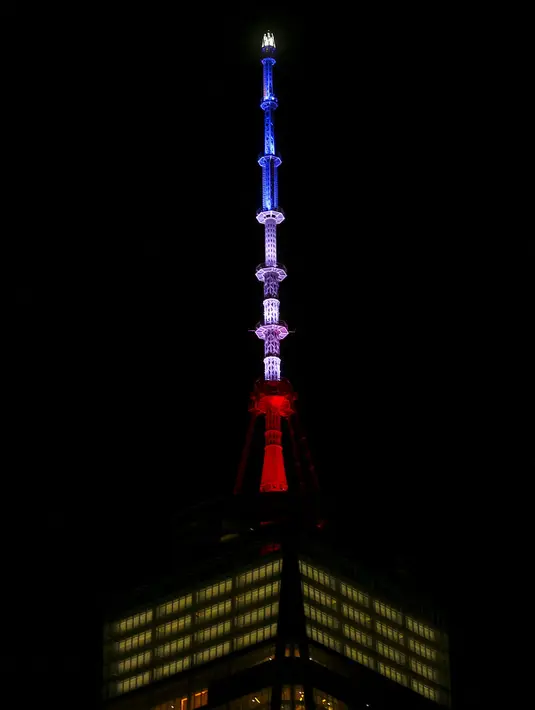 One World Trade Center menyala dengan warna bendera Prancis yaitu warna biru, putih dan merah di Manhattan boroug, New York (13/11). Aksi ini sebagai ungkapan belasungkawa menyusul serangan teror di Perancis. (REUTERS/Carlo Allegri)