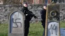 Aparat kepolisian melakukan penjagaan di sekitar kompleks pemakaman Yahudi yang menjadi sasaran aksi vandalisme, Westhoffen, dekat Strasbourg, Prancis, Rabu (4/12/2019). Sedikitnya 107 makam menjadi sasaran vandalisme dengan dicoreti lambang swastika Nazi. (AFP/Patrick Hertzog)