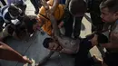 Dua orang pria kesurupan saat mengikuti festival tato suci di Biara Wat Bang Phra, Nakhon Pathom, Thailand (3/3). Festival tato suci tersebut festival tato suci festival yang digelar setiap tahunnya. (AFP Photo/Lillian Suwanrumpha)