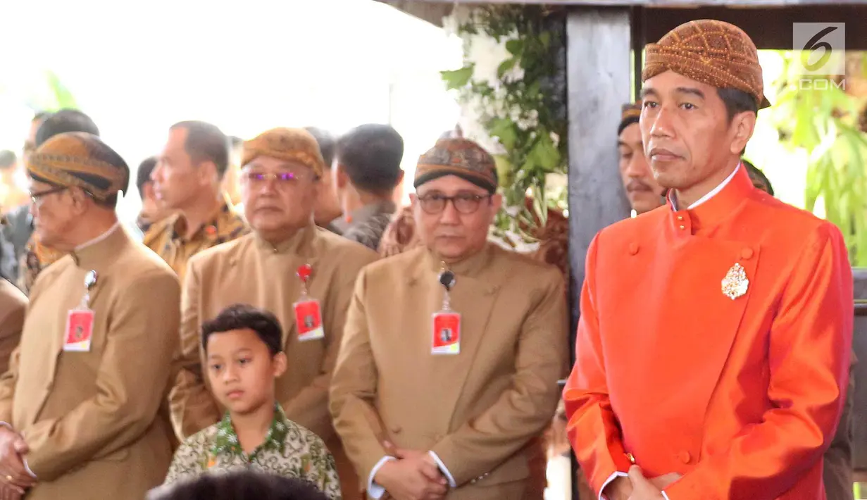 Presiden Joko Widodo (Jokowi) bersiap melakukan pemasangan Bleketepe pernikahan Kahiyang Ayu dan Bobby Nasution di kediamannya Jalan Kutai Utara, Solo, Selasa (7/11). Jokowi mengenakan beskap berwarna oranye dan blangkon. (Liputan6.com/Angga Yuniar)