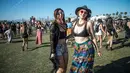 Dua wanita tersenyum saat menghadiri Festival Musik Coachella dan Arts Festival di Indio, California (15/4). Festival ini selalu ditunggu pecinta musik dunia dan juga selebriti Hollywood. (Photo by Amy Harris/Invision/AP)
