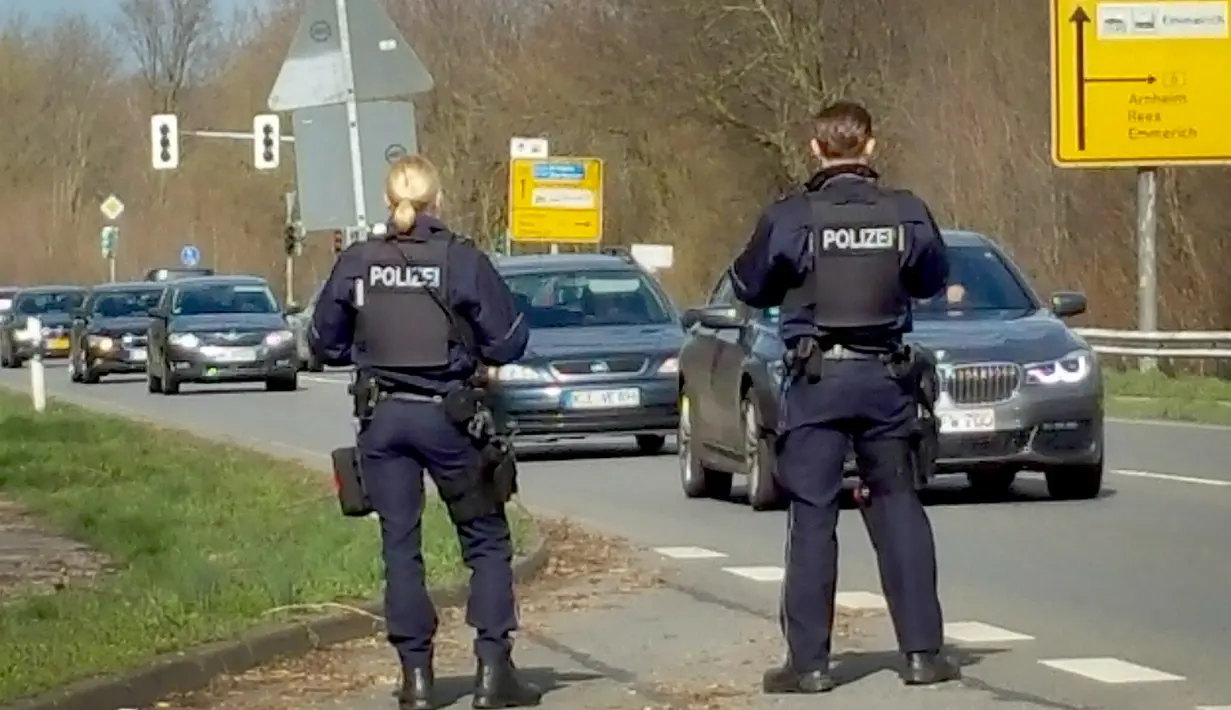 Aparat kepolisian berjaga di perlintasan antar negara di Kleve, Jerman barat, dekat perbatasan Belanda, Senin (18/3). Perburuan besar-besaran dilakukan aparat keamanan Belanda terhadap Gokmen Tanis, pelaku penembakan di Utrecht. (Guido SCHULMANN/dpa/AFP)