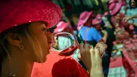 Seorang wanita mencicipi segelas anggur mawar Spanyol untuk mempromosikan minuman tersebut di Pamplona, Spanyol, Sabtu (19/5). Anggur mawar Spanyol merupakan minuman khas wilayah tersebut. (AP Photo/Alvaro Barrientos)