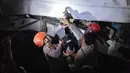 Tim penyelamat bekerja di lokasi terjadinya tabrakan kecelakaan Kereta Api Jarak Jauh (KAJJ) Argo Bromo Anggrek dengan Kereta Rel Listrik (KRL) Commuter Line di Stasiun Bekasi Timur, Jawa Barat, pada Selasa 28 April 2026 dini hari. (Yasuyoshi Chiba/AFP)