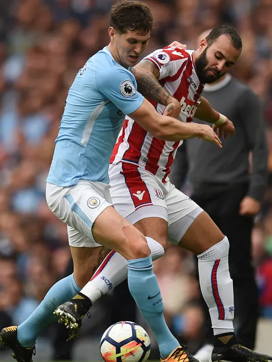 Bek Manchester City, John Stones berusaha merebut bola yang dibawa penyerang Stoke City, Jese saat bertanding pada lanjutan Liga Inggris di Etihad Stadium, Manchester, (14/10). City menang 7-2 atas Stoke. (AFP Photo/Oli Scarff)