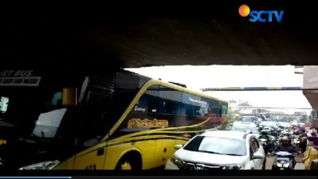 Bus pariwisata berisi para mahasiswa ini tersangkut karena tinggi bus melebihin tinggi terowongan.