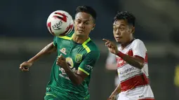 Gelandang Persebaya Surabaya, Koko Ari (kiri) berebut bola dengan striker Madura United, Mochammad Kevy dalam laga matchday ke-2 Grup C Piala Menpora 2021 di Stadion Si Jalak Harupat, Bandung, Minggu (28/3/2021). (Bola.com/M Iqbal Ichsan)