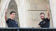 Pemain baru AC Milan, Gonzalo Higuain (kanan) dan Mattia Caldara menyapa suporter dari balkon di alun-alun pusat Milan Piazza Duomo (3/8). Higuain dan Caldara didapatkan Milan dari Juventus. (AFP Photo)