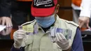 Petugas Komisi Pemberantasan Korupsi (KPK) menunjukkan barang bukti penangkapan Wakil Ketua DPRD Provinsi Jawa Timur 2019-2024, Sahat Tua P. Simandjuntak bersama tiga orang lainnya di Gedung Merah Putih KPK, Jakarta, Kamis (15/12/2022). Sahat Tua P. Simandjuntak bersama tiga orang lainnya terjerat OTT KPK berikut barang bukti uang dengan nilai seluruhnya Rp1 miliar. (Liputan6.com/Helmi Fithriansyah)