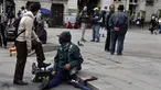 Tukang semir sepatu bertopeng melayani pelanggannya di kawasan La Paz, Bolivia (29/11). Dengan menutup wajahnya para tukang semir ini menyembunyikan identitas karena pekerjaan tersebut dipandang rendah oleh masyarakat lokal. (AFP PHOTO/Aizar Raldes)