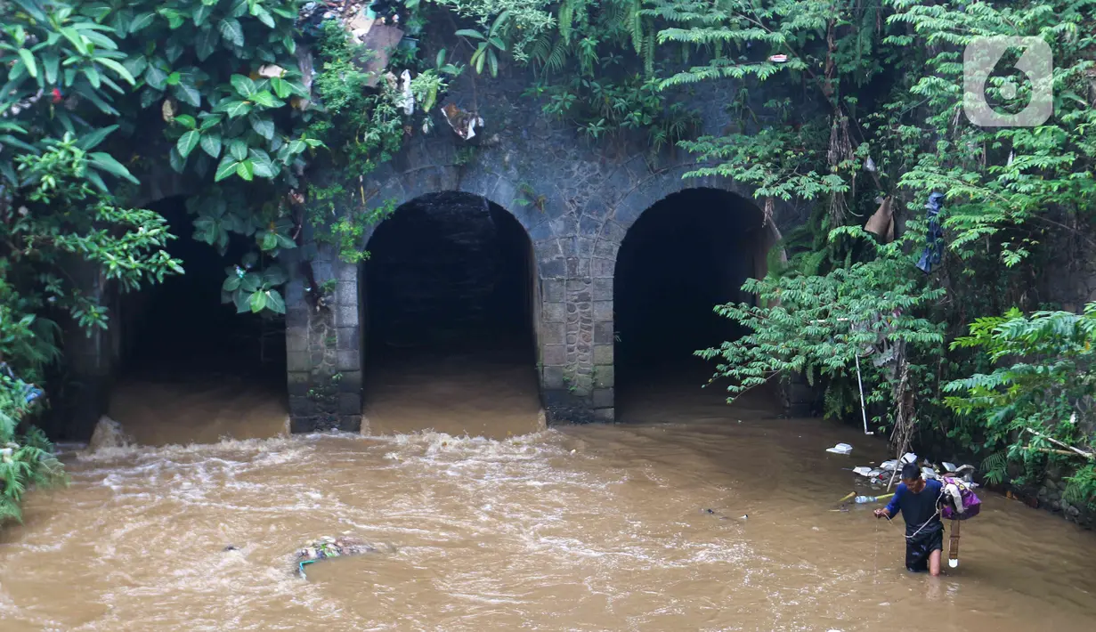 Warga berjalan di depan bangunan Jembatan Terowongan Tiga di kawasan Matraman, Jakarta, Minggu (12/6/2022). Jembatan Terowongan Tiga yang ditetapkan sebagai bangunan cagar budaya oleh Pemprov DKI Jakarta tersebut kondisinya terbengkalai dan kumuh. (Liputan6.com/Herman Zakharia)