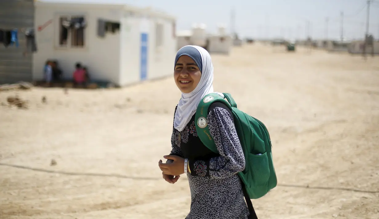Omayma berjalan pulang sekolah di kamp pengungsi Al Zaatari, Mafraq, Yordania (21/4). Omayma Al Hushan menyerukan perlawanan terhadap pernikahan dini yang marak negaranya. (REUTERS / Muhammad Hamed)