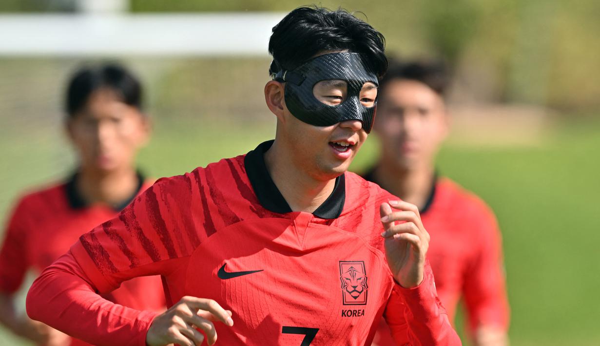 Kapten timnas Korea Selatan Son Heung-min mengenakan masker pelindung saat mengikuti sesi latihan menjelang dimulainya Piala Dunia 2022 Qatar, di Al Egla Training Site 5 di Doha, Rabu (16/11/2022). Son tampil dengan topeng, yang tampaknya terbuat dari serat karbon yang biasa digunakan dalam beberapa tahun terakhir. (Jung Yeon-je / AFP)