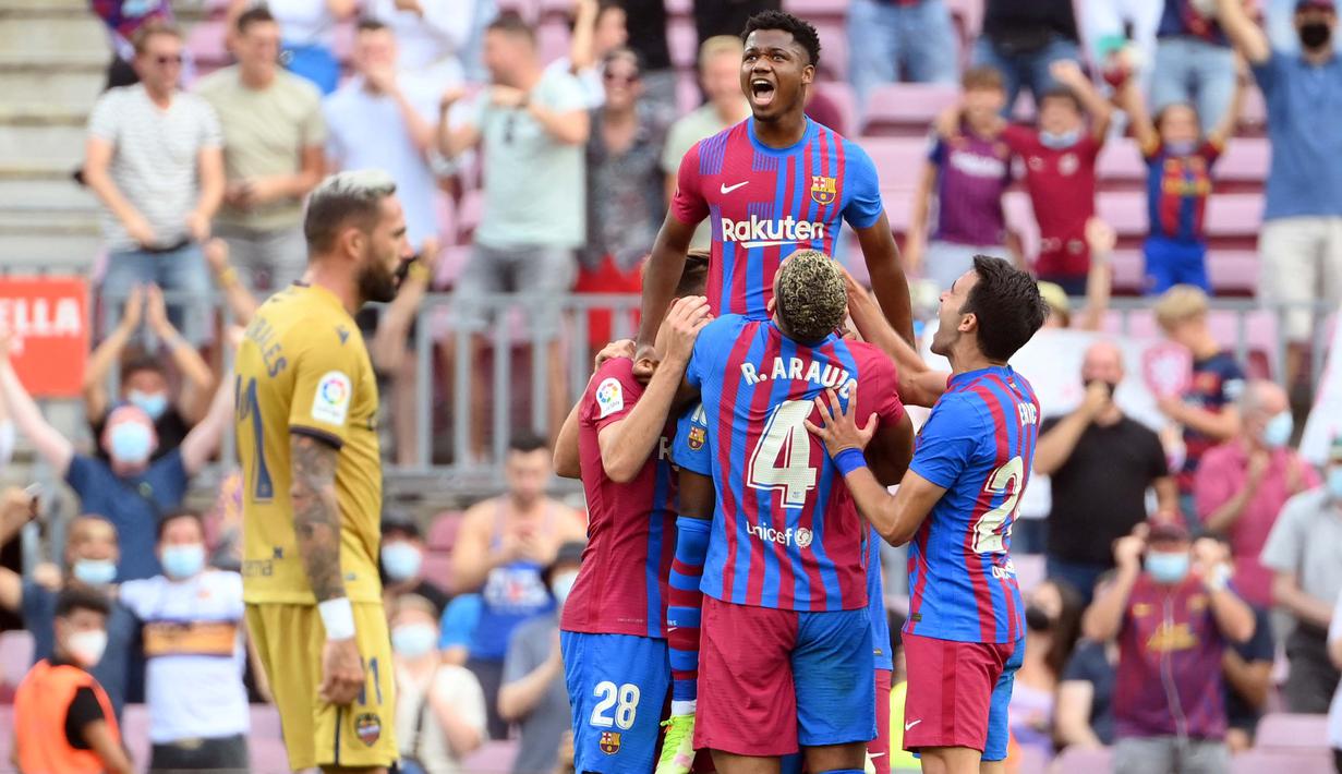 Ansu Fati yang tampil untuk pertama kali bagi Barcelona langsung menorehkan namanya di papan skor saat timnya mengalahkan Levante 3-0. Sontak seluruh pemain langsung menghampiri dan mengangkatnya layaknya seorang raja. (AFP/Lluis Gene)
