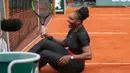 Serena Williams tertawa setelah ia tergelincir di lapangan saat melawan Krystina Pliskova dalam turnamen tenis Perancis Terbuka di stadion Roland Garros di Paris, Prancis (29/5). (AP / Michel Euler)