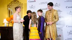Bintang film Bollywood Shah Rukh Khan bercengkerama dengan putri Perdana Menteri (PM) Kanada Justin Trudeau, Ella Grace di Mumbai, India, Selasa (20/2). (Sean Kilpatrick/Canadian Press via AP)