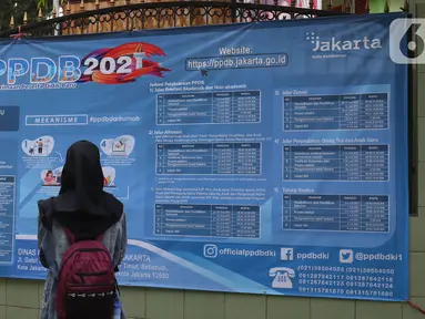 Orang tua murid mencari informasi pengajuan akun untuk mengikuti proses penerimaan Peserta Didik Baru (PPDB) Tahun Pelajaran 2021/2022 di SMA Negeri 87 Jakarta, Senin (7/6/2021).  (Liputan6.com/Herman Zakharia)