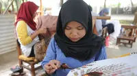 Perajin membuat batik tulis khas Betawi di rumah produksi Keluarga Batik Betawi, Setu Babakan, Jakarta Selatan, Minggu (10/3). Kain batik Betawi ini dijual seharga Rp 135  ribu hingga Rp 800 ribu per helai. (merdeka.com/Arie Basuki)