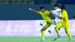 Pemain Timnas Indonesia U-17, Dava Yunna Adi Putra, berusaha melewati pemain Malaysia pada laga kedua Grup A Piala AFF U-17 2026 di Stadion Gelora Joko Samudro, Gresik, Jawa Timur, Kamis (16/4/2026) malam. (Bola.com/M Iqbal Ichsan)