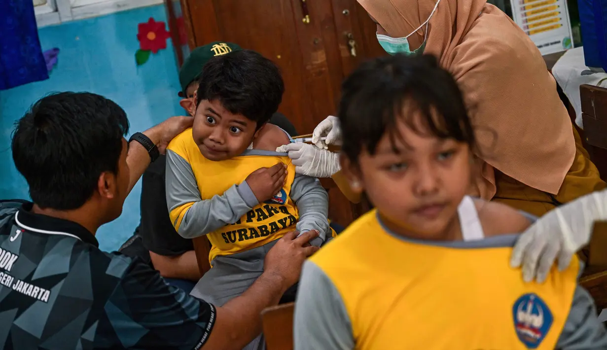 Para siswa menerima vaksin difteri di sebuah sekolah dasar di Surabaya pada Selasa 4 November 2025. Untuk diketahui, program BIAS merupakan agenda rutin untuk memastikan anak-anak terlindungi dari penyakit menular yang dapat dicegah melalui imunisasi. (Juni KRISWANTO/AFP)