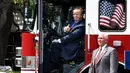 Presiden AS, Donald Trump mengacungkan jempol sambil duduk di sebuah truk pemadam kebakaran saat bersama Wapres Mike Pence menghadiri acara pameran produk bertajuk "Made in America" di Gedung Putih, Washington, Senin (17/7). (Olivier Douliery/AFP)