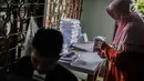 Sejumlah pekerja melipat surat suara Pemilihan Umum 2019 di gudang logistik KPU Jakarta Pusat, Selasa (19/2). Tugas pertama para pekerja ialah menyortir surat suara antara surat suara yang cacat dan yang tidak cacat. (Liputan6.com/Faizal Fanani)