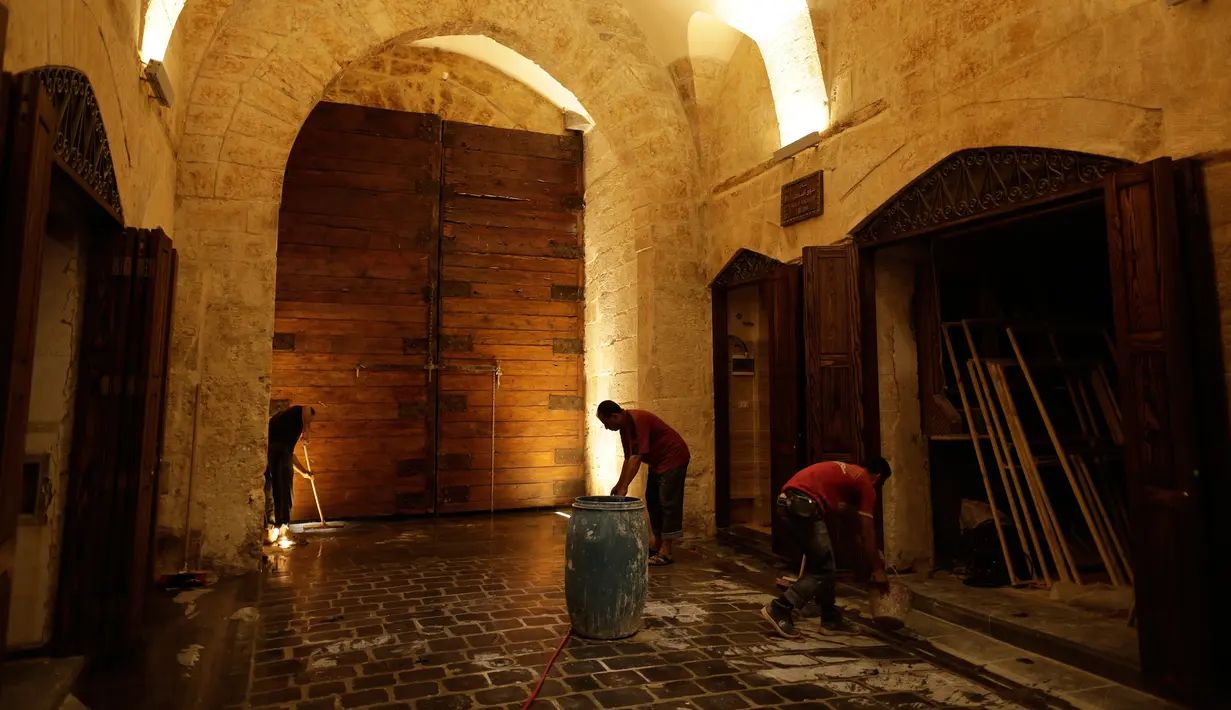 Pekerja membersihkan Pasar al-Saqatiyah yang baru saja direnovasi di Kota Tua Aleppo, Suriah, Sabtu (27/7/2019). Kegiatan ekonomi perlahan mulai tumbuh tiga tahun setelah pertempuran besar terjadi di Aleppo. (AP Photo/Hassan Ammar)