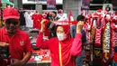 Seorang wanita mengenakan atribut Timnas Indonesia jelang pertandingan AFF 2022 antara Indonesia melawan Thailand di Stadion Gelora Bung Karno, Jakarta, Kamis (29/12/2022). Atribut timnas Indonesia seperti kaos, syal, dan topi dijual dengan kisaran harga Rp35.000 hingga Rp75.000. (Liputan6.com/Faizal Fanani)