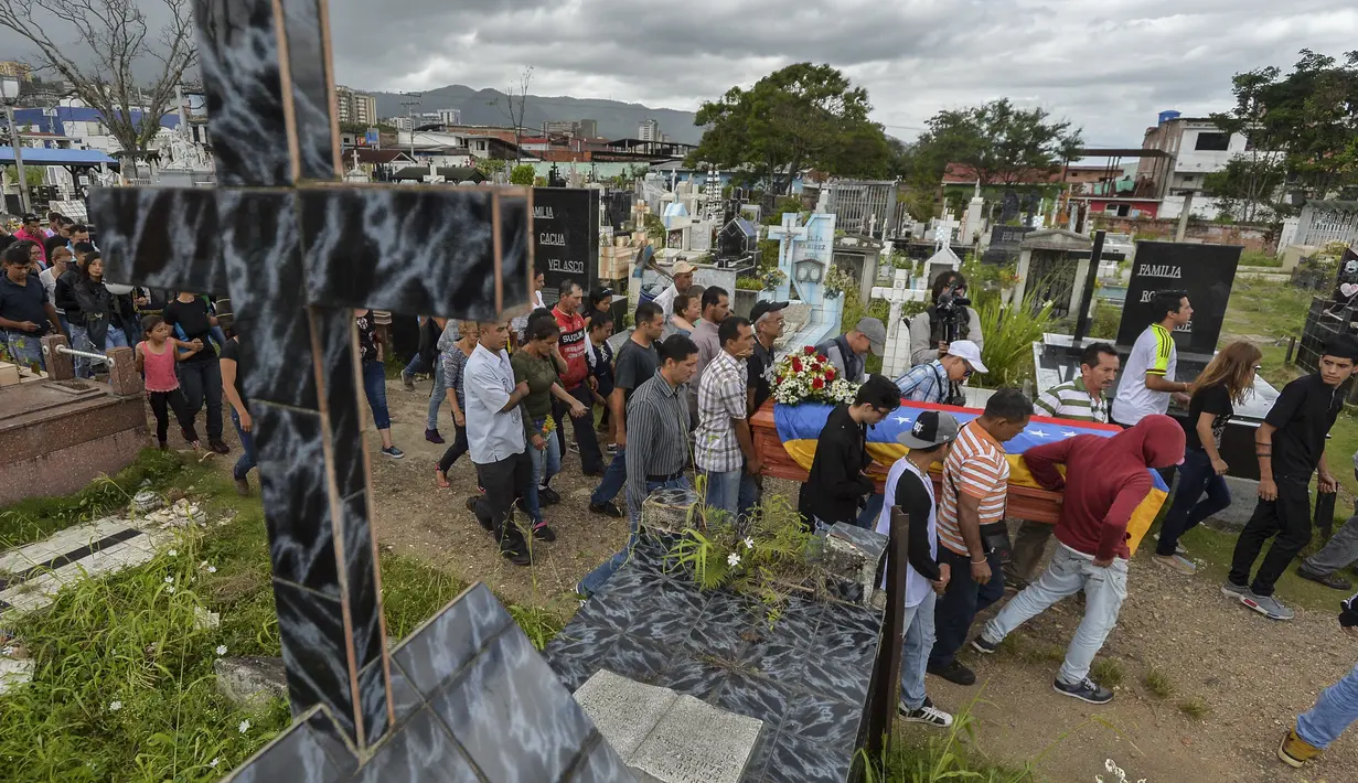 Keluarga dan kerabat mengantarkan jenazah Jose Francisco Guerrero untuk dimakamkan di San Cristobal, Tachira State, Venezuela (19/5). (AFP/Luis Robayo)