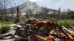 Sepeda motor yang terbakar lava panas dari Gunung Sinabung terlihat di perkebunan yang ditinggalkan warganya, di Desa Beras Tepu, Karo, Sumatera Utara, 21 Juni 2015. (REUTERS/Beawiharta)