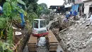 Alat berat mengangkut puing bangunan yang roboh akibat longsornya turap Kalibaru di Desa Putra, Jakarta Selatan, Rabu (22/3). Selain menambal turap bocor, petugas juga mengangkat kotoran sungai agar tidak terjadi pendangkalan. (Liputan6.com/Yoppy Renato)