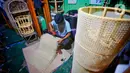 Perajin menyelesaikan pembuatan kerajinan dari rotan di kawasan Tangerang, Banten, Rabu (17/2/2021). Pandemi corona memukul banyak sektor usaha tak terkecuali UMKM akibat adanya pembatasan aktivitas masyarakat yang membuat omzet penjualan kerajinan rotan menurun. (Liputan6.com/Angga Yuniar)