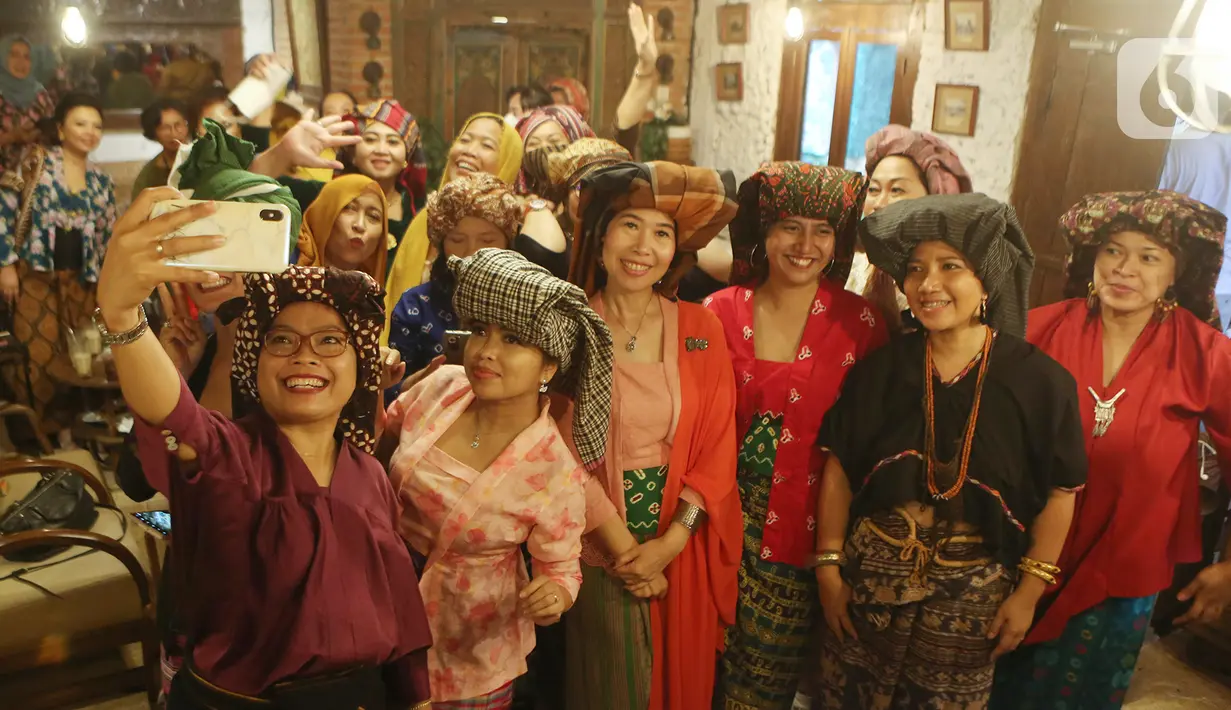 Perempuan dengan penutup kepala Tengkuluk berswafoto pada acara Ngopi Tengkuluk, Mengenal Penutup Kepala Perempuan Indonesia di Depok, Minggu (26/09/2021). Sejumlah perempuan dari berbagai komunitas mengajak generasi muda untuk menghargai dan merawat keragaman. (Liputan6.com/HO/Sybli)