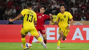 Pemain Timnas Indonesia U-23, Victor Dethan (tengah), berduel dengan dua pemain Malaysia U-23 pada laga pemungkas Grup A Piala AFF U-23 2025 di Stadion Utama Gelora Bung Karno (SUGBK), Senin (21/7/2025) malam WIB. (Bola.com/Abdul Aziz)